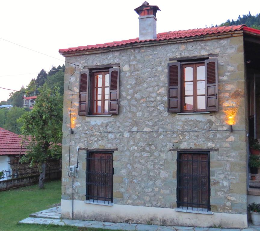 una casa de piedra con cuatro ventanas en el lateral. en Traditional Stone House, en Elati