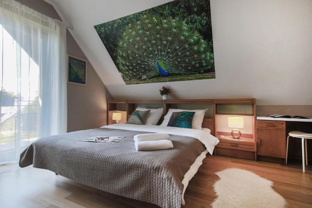 a bedroom with a large bed with a painting on the wall at Villa Aviator in Jaworze