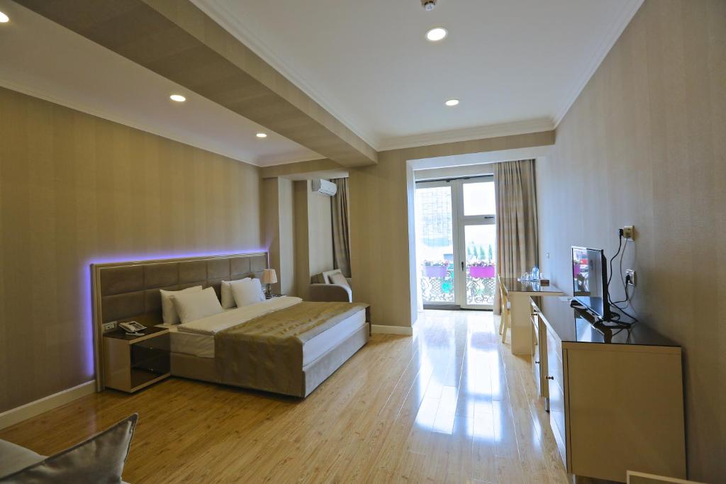 een slaapkamer met een bed en een groot raam bij Rusel Hotel in Baku
