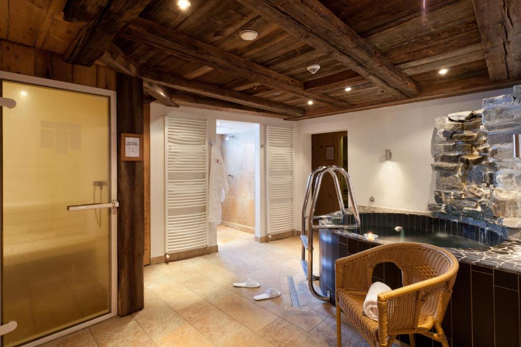 a bathroom with a walk in shower and a glass door at Hotel Montfort in Sankt Anton am Arlberg