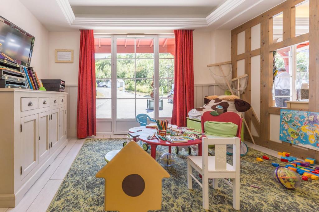 a childs play room with a table and chairs at Pierre & Vacances Premium Residence & Spa Houlgate in Houlgate