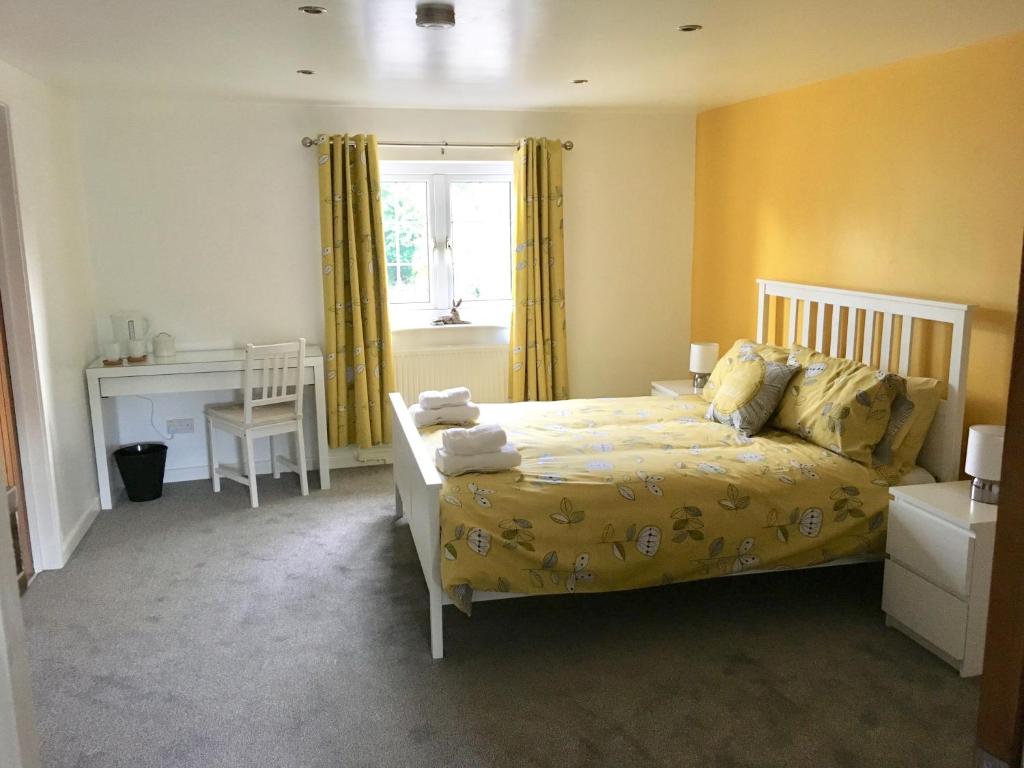 a bedroom with a bed and a desk and a window at The Sun B&B Rooms in Winforton
