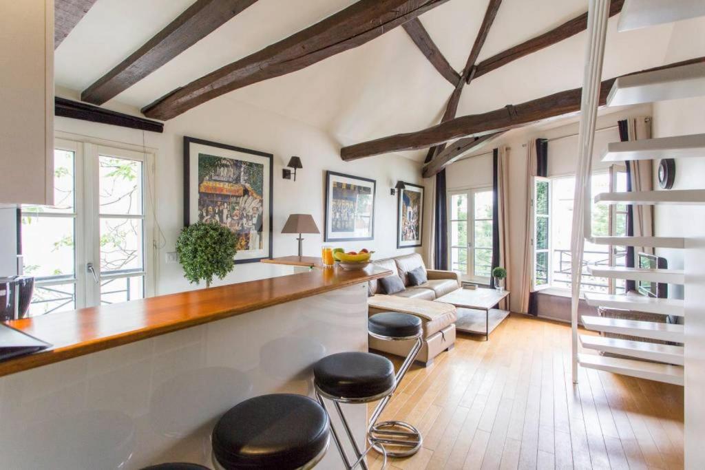 a living room with a wooden counter and stools at Luxurious Duplex - Top of Montmartre in Paris