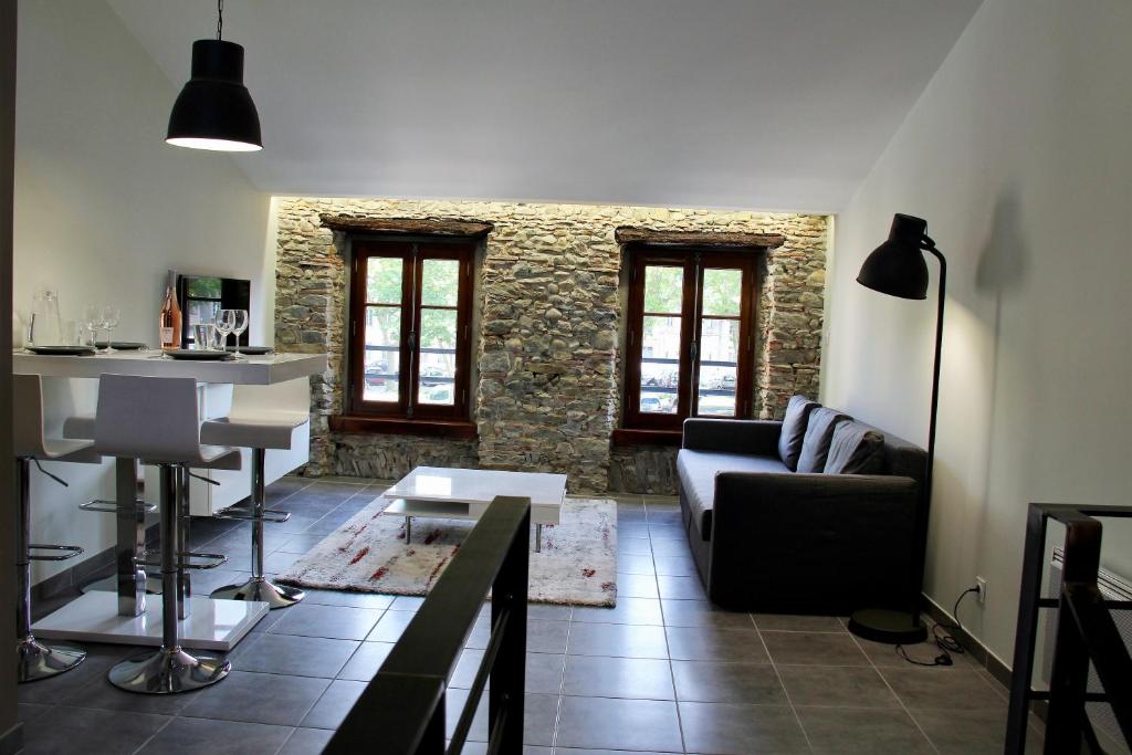 een woonkamer met een bank en een tafel bij Le Voltaire in Carcassonne