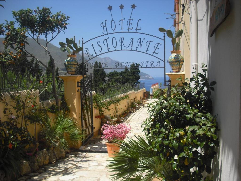 a garden with a gate with flowers and plants at Torre Bennistra in Scopello