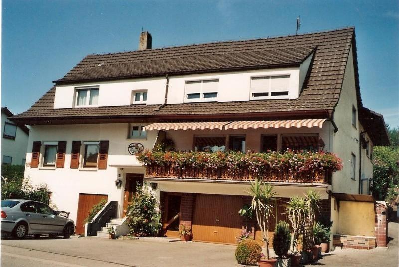uma casa branca com flores ao lado dela em Ferienwohnung Sick em Uhldingen-Mühlhofen