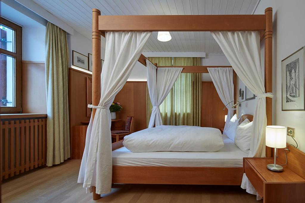 a bedroom with a canopy bed with white sheets at Villa Christina in San Candido