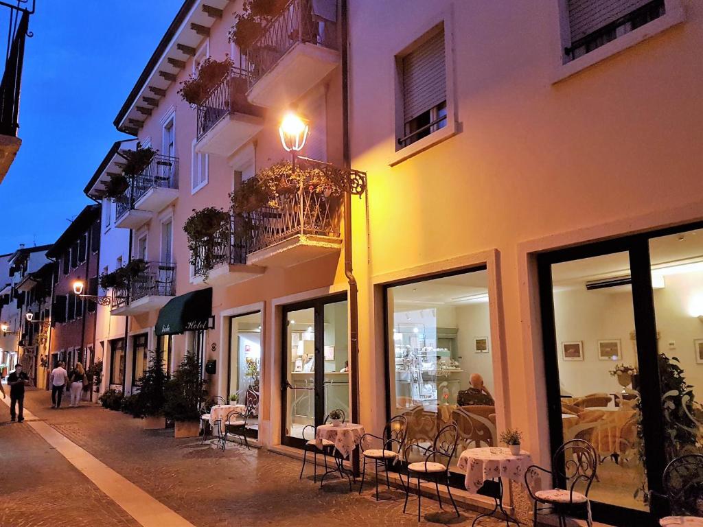 uma rua com mesas e cadeiras fora de um edifício em Albergo Fiorita em Bardolino