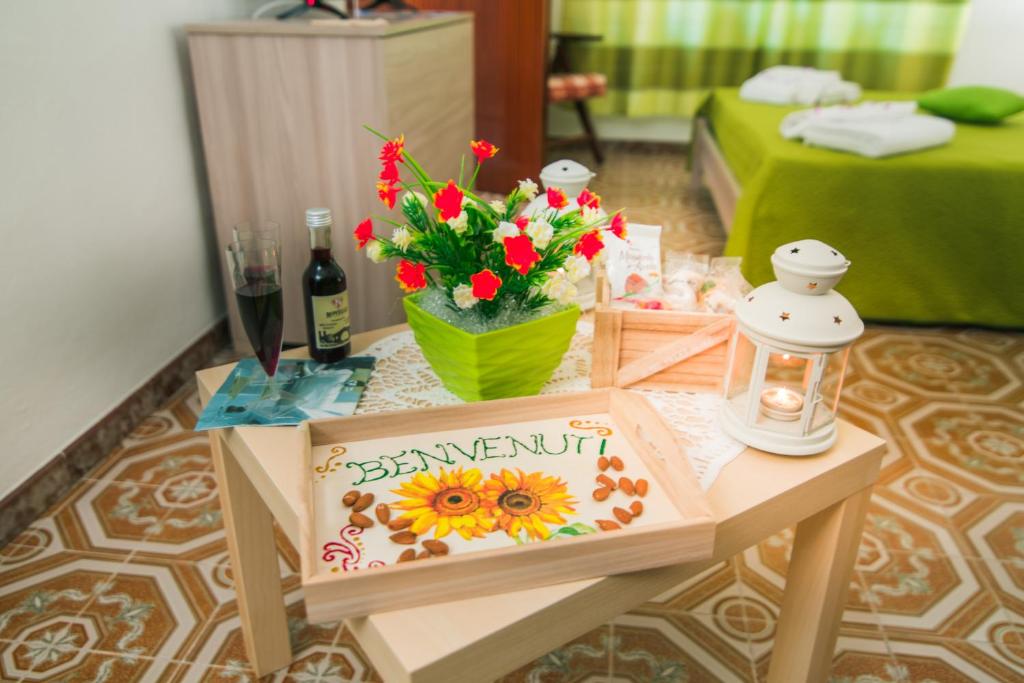 uma mesa com flores e um cartaz em B&B U PRUFISSURI em Avola