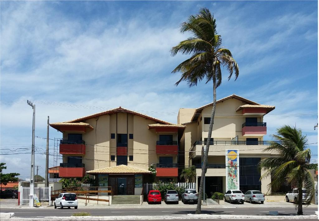 um edifício com uma palmeira em frente em Via Mar Praia Hotel em Aracaju