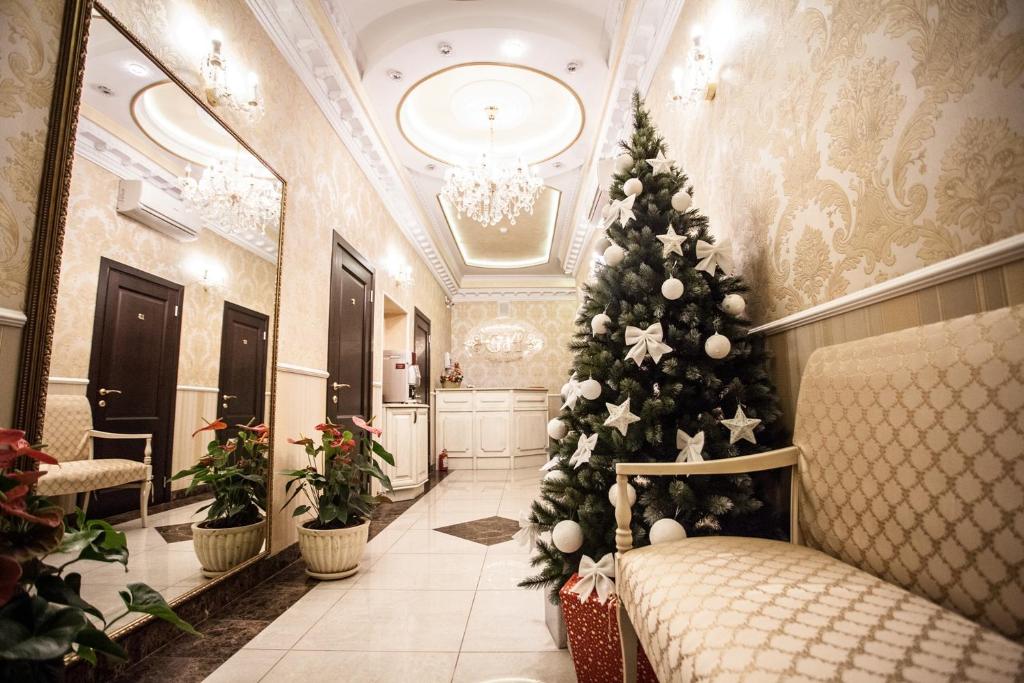 a christmas tree in a hotel lobby with a christmas decoration at Guest House Roma in Saint Petersburg