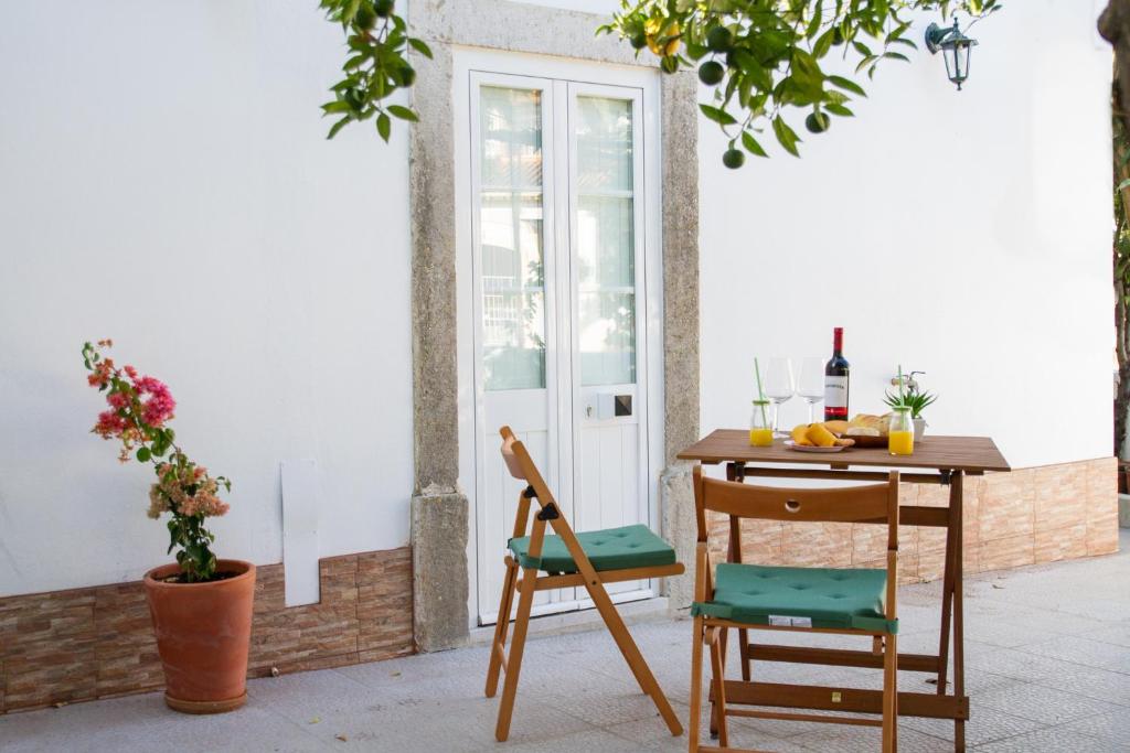 uma mesa e cadeiras sentadas ao lado de uma mesa em Casa dos Avós em Villa Nogueira
