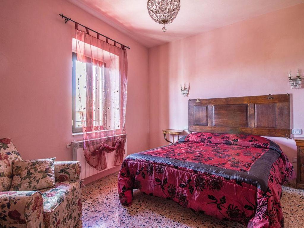 1 dormitorio con 1 cama, 1 silla y 1 ventana en Le Casette Country House en Petricci