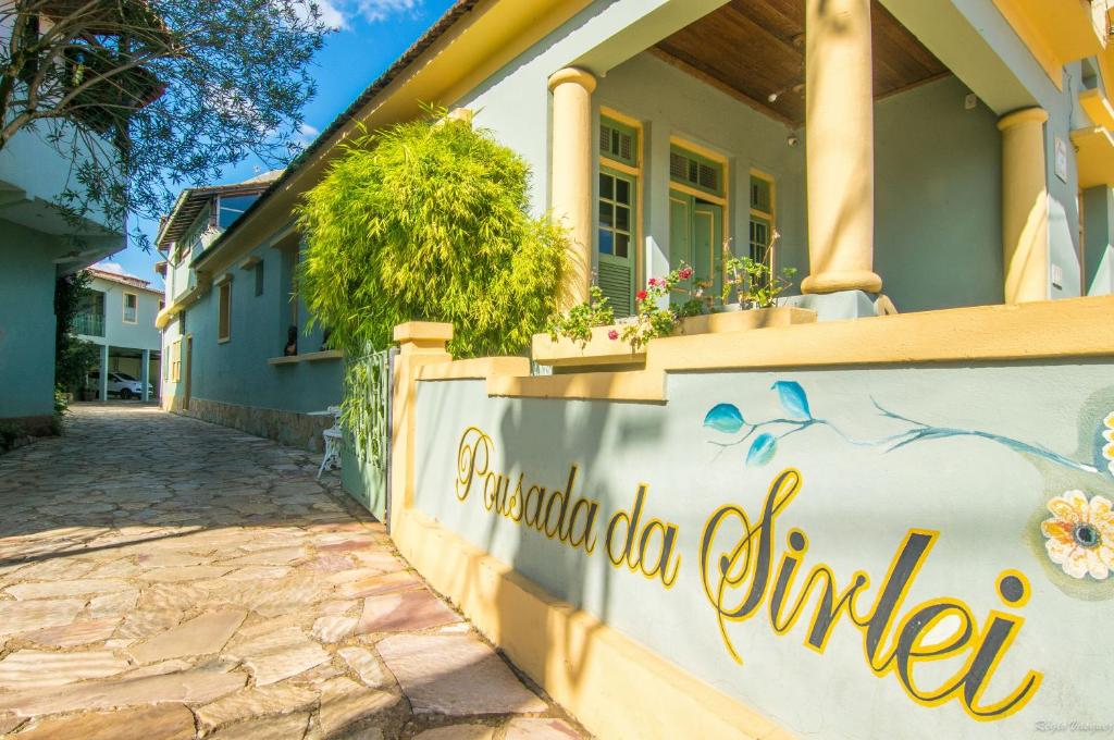 een huis met een bord dat het Spaanse dorp del mundo verenigt bij Pousada da Sirlei in Tiradentes
