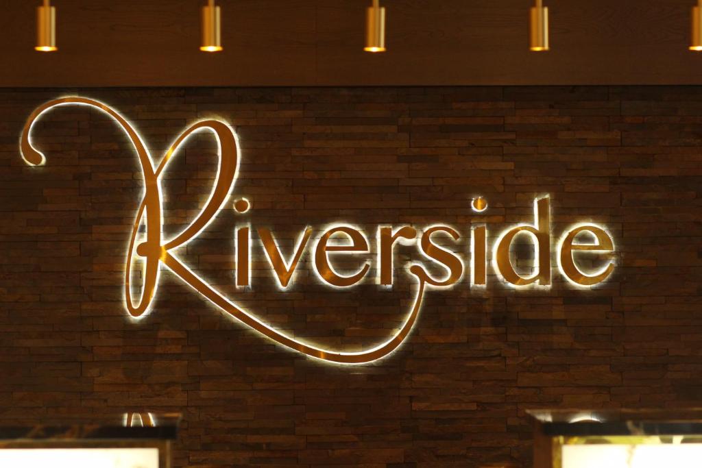 a neon sign that says exercise on a brick wall at Riverside Lodge Hotel in Irvine