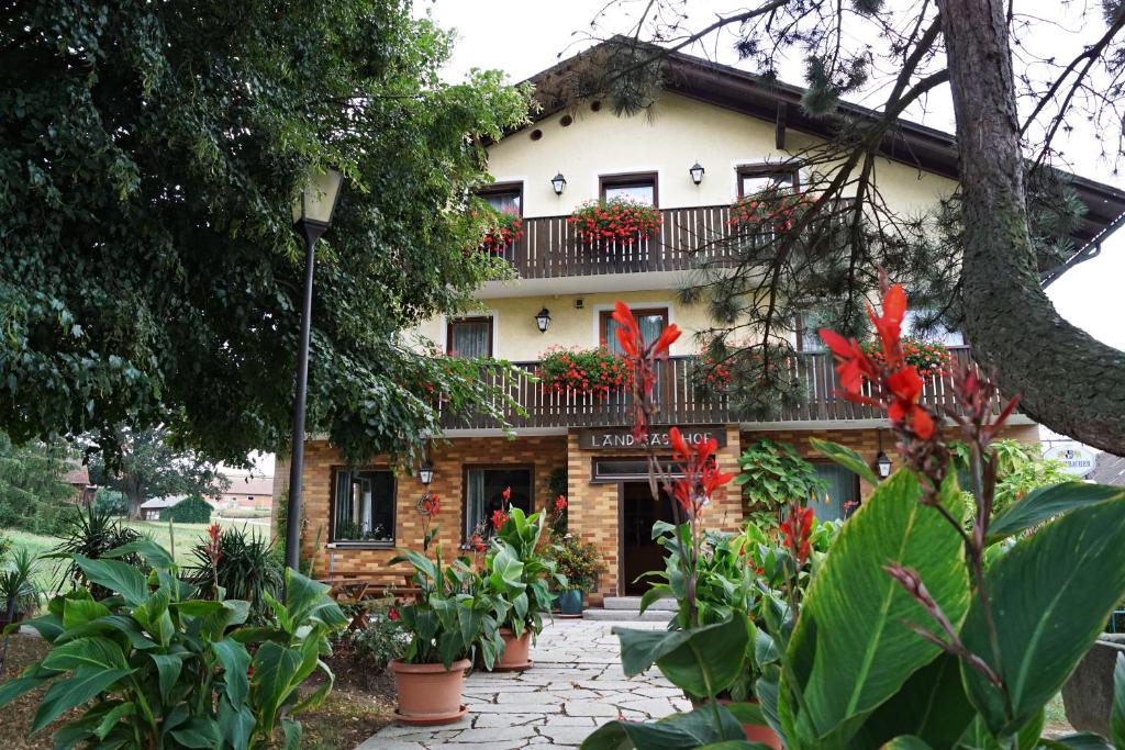 a house with a balcony and flowers on it at Hotel-Landgasthof Henghuber in Rötz