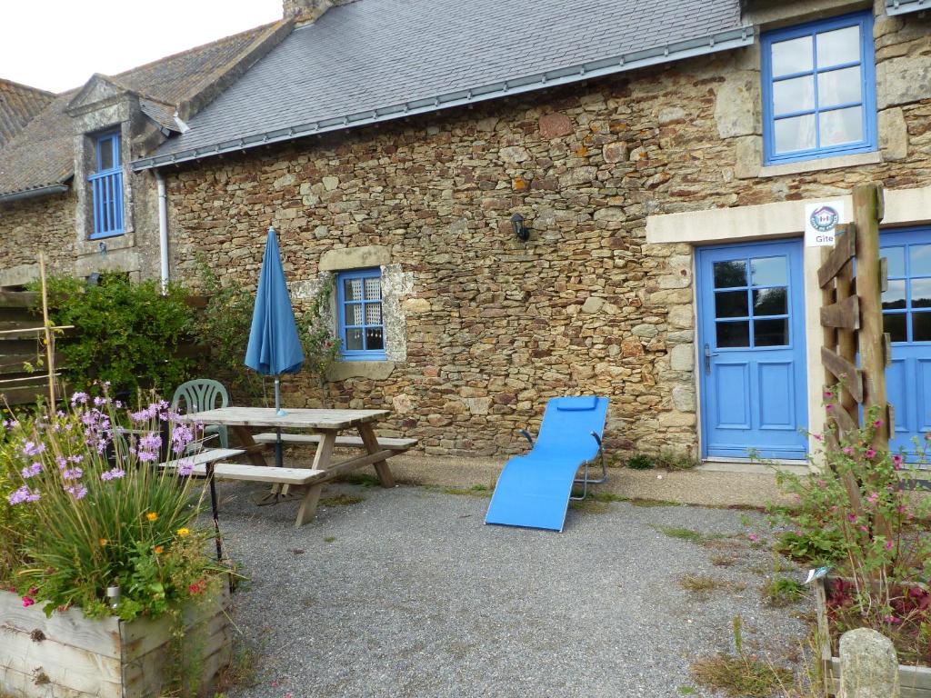 a stone building with a picnic table and a blue door at Coqueno in Sarzeau