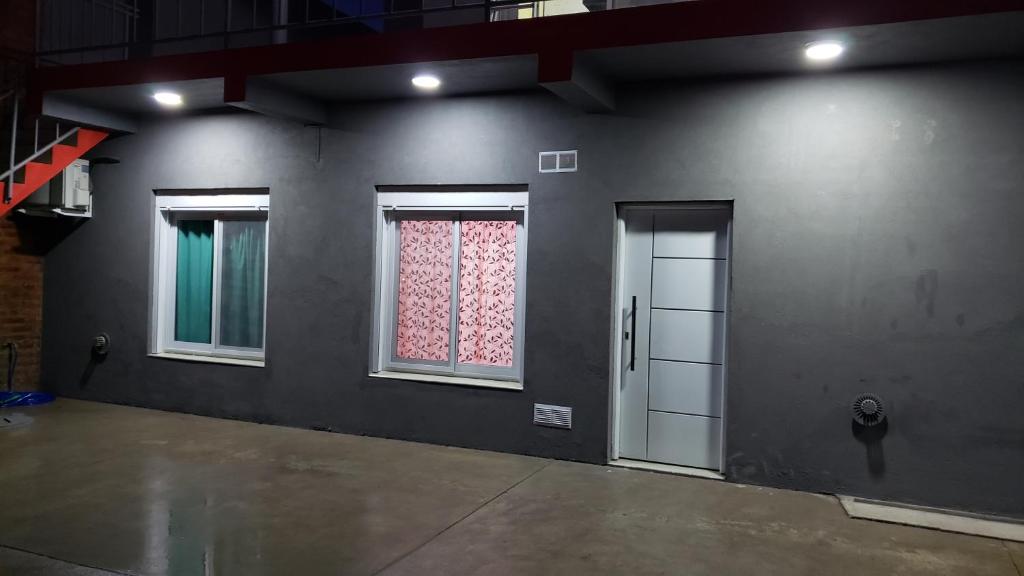 an empty room with two windows and a door at Complejo EL ANGEL in Río Colorado