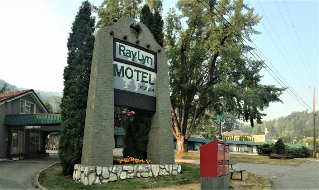 una señal para un motel al lado de una carretera en Ray Lyn Motel en Trail