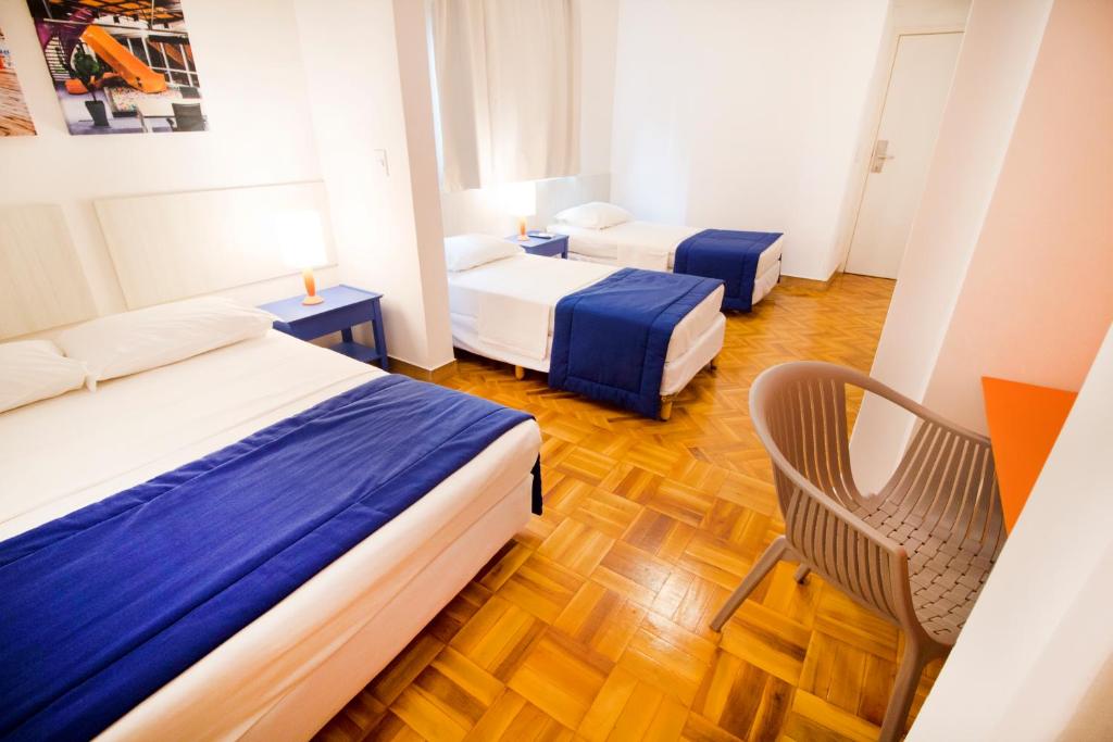 a hotel room with two beds and a chair at Hotel Villa Smart in Fortaleza