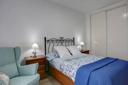 エステポナにあるVista Al Faroのベッドルーム1室(ベッド1台、青い椅子付)