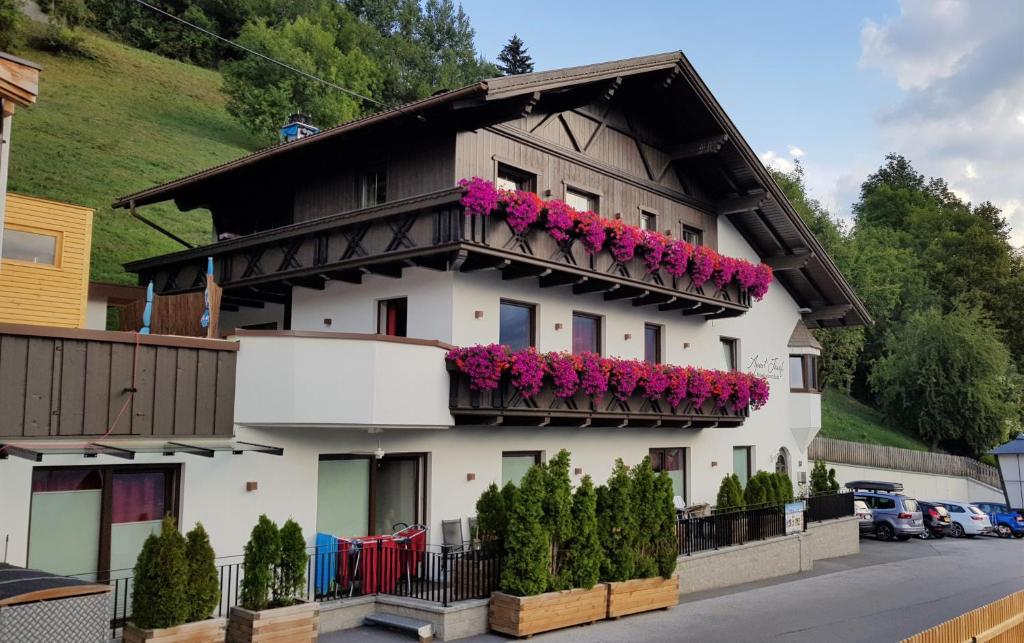 a white building with pink flowers on the balconies at Apart Josef in Ladis
