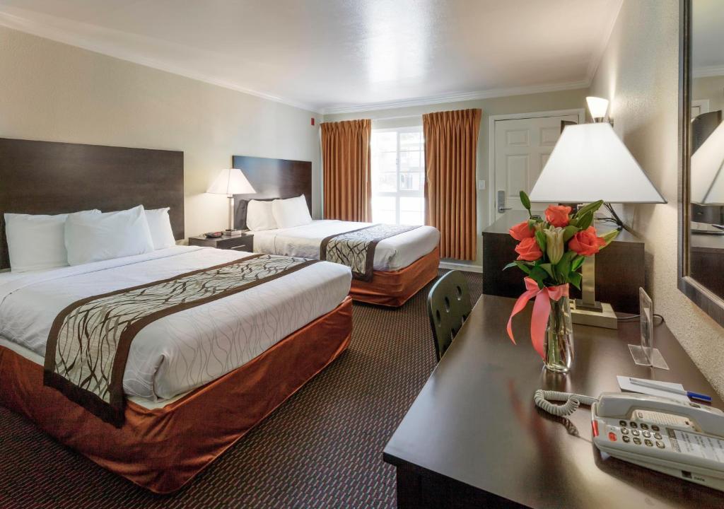 Habitación de hotel con 2 camas y escritorio en Thunderbird Lodge, en Redding