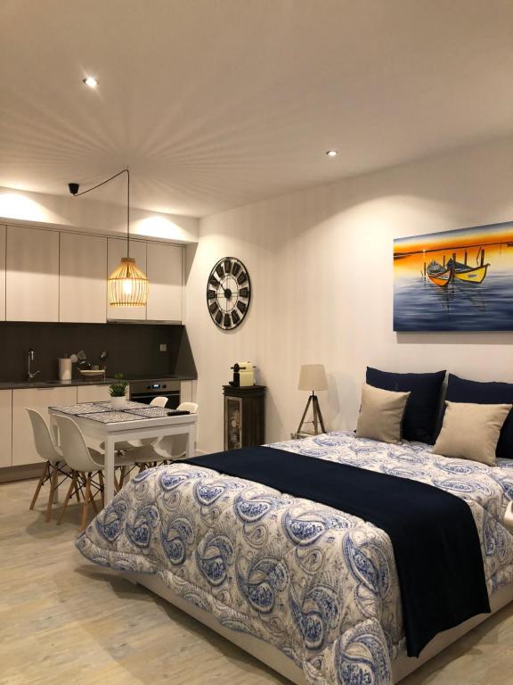 a bedroom with a large bed and a kitchen at Aveiro 5 Estrelas in Aveiro