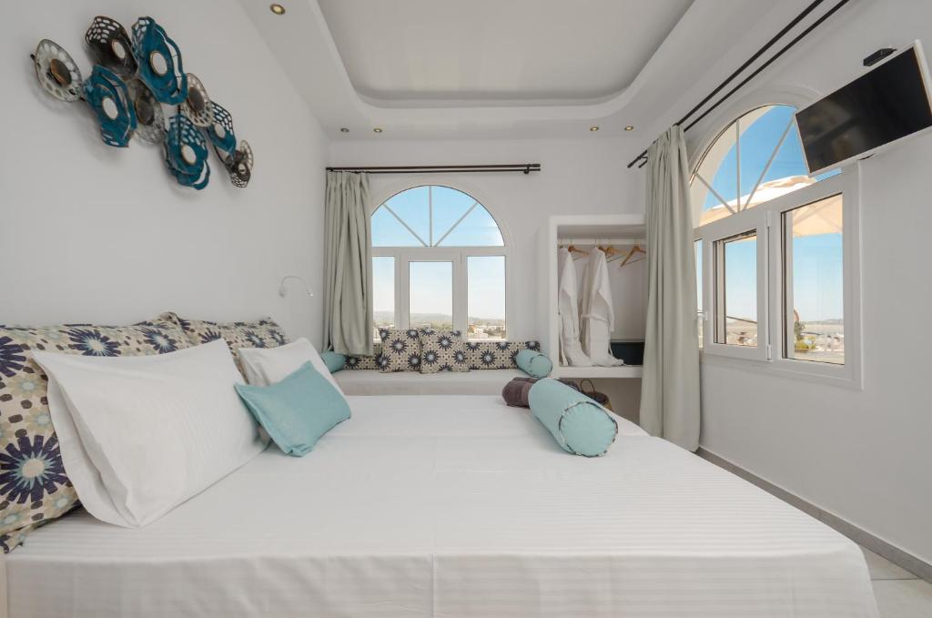 a large white bed in a room with windows at Naxos Dream Oniro Studios - Adults Only in Naxos Chora