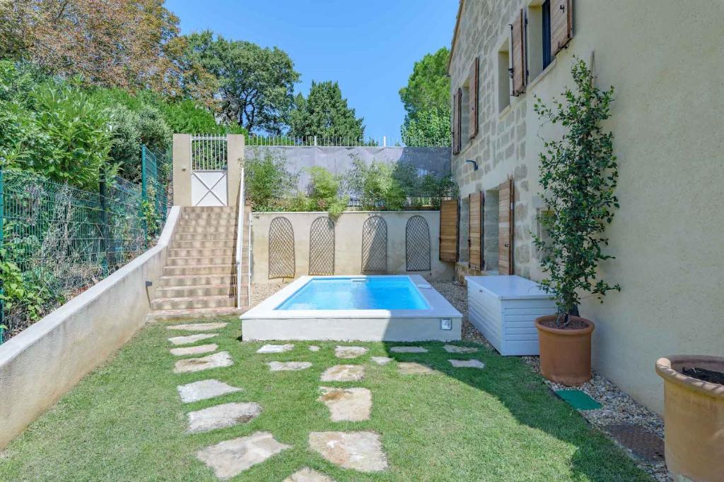 un patio trasero con piscina y valla en La maison du Boulodrome, en La Bruguière