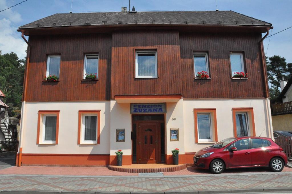 a red car parked in front of a house at Penzion Zuzana in Staré Splavy