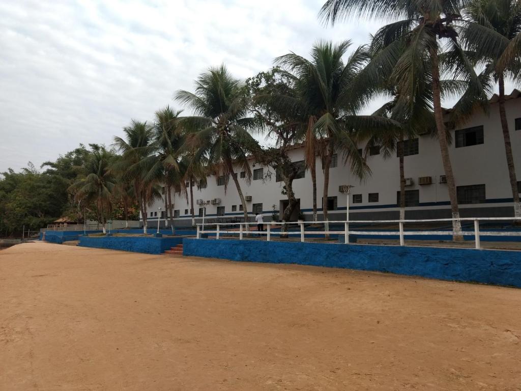 a building with palm trees in front of it at Hotel Pintado Azul in Coxim
