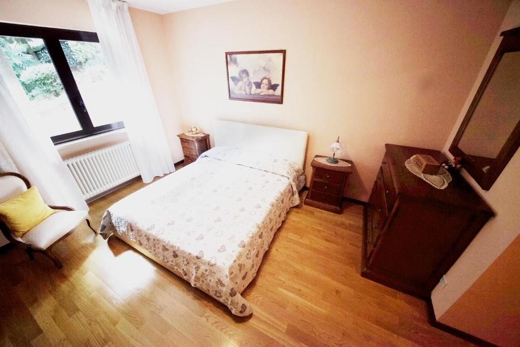 um quarto com uma cama, uma cómoda e uma janela em Villetta maison hélène em Aosta