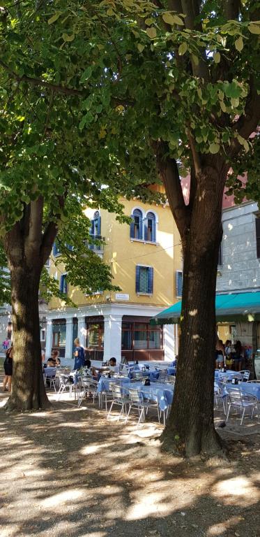 two trees with tables and chairs in front of a building at BB Venezia in Venice