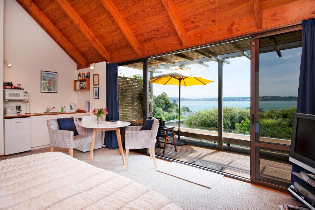 a bedroom with a bed and a table with a view at Te Manaaki Villa in Russell