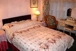 a bedroom with a bed and a chair and a desk at Knightsrest in Burnham on Sea