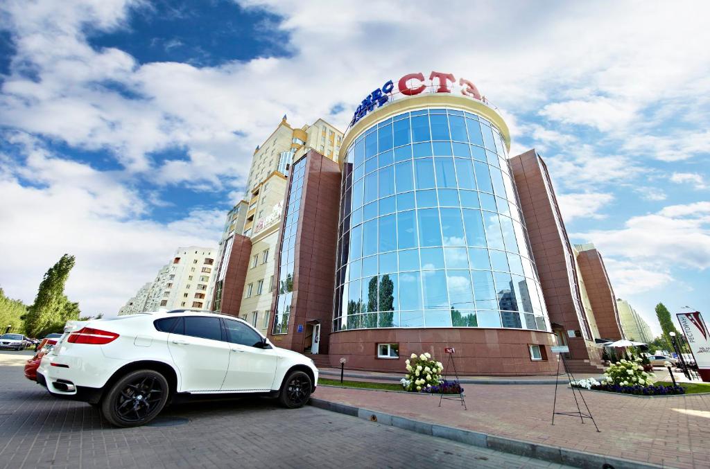 um carro branco estacionado em frente a um edifício em Valeri Classic em Voronezh