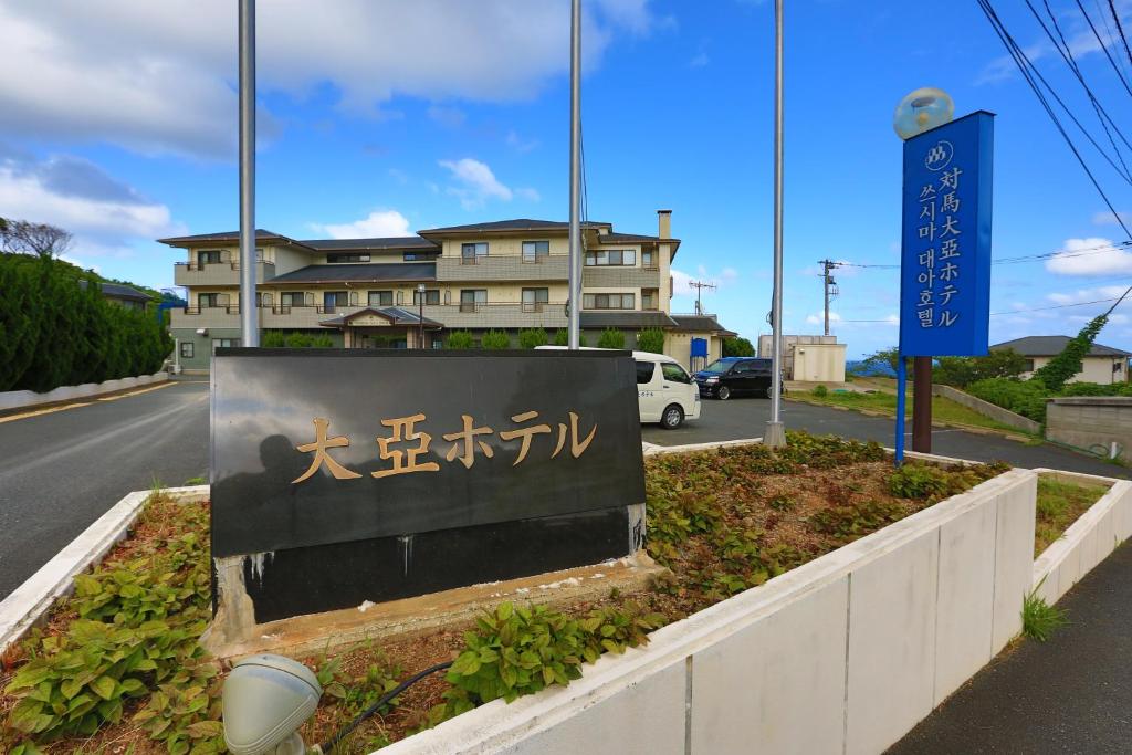 a sign for a building next to a street at Tsushima Dae-A Hotel in Tsushima