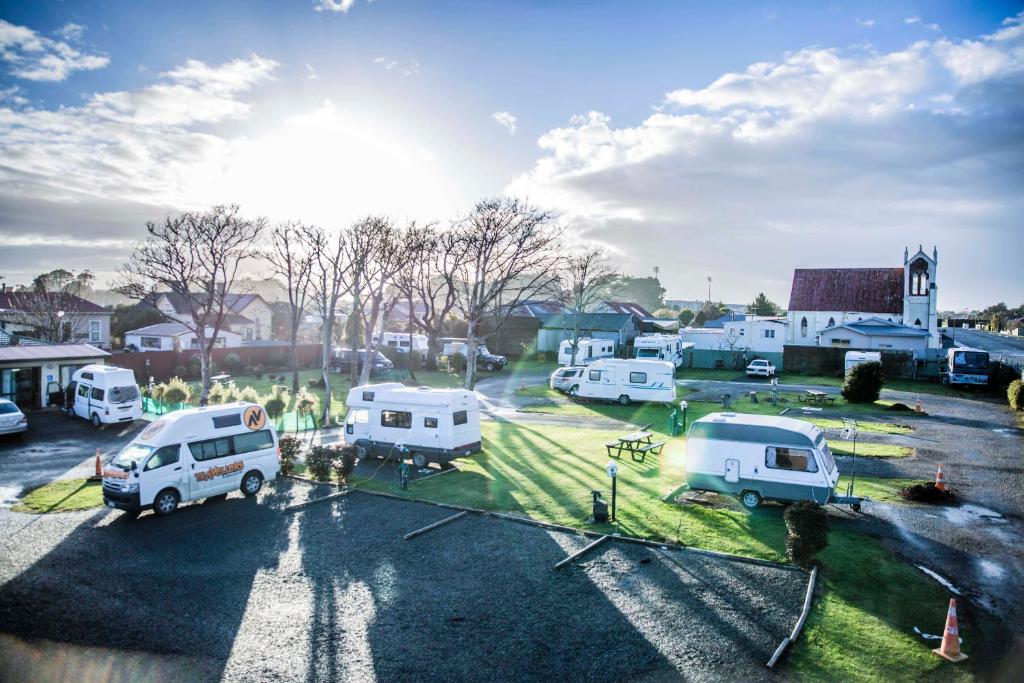 un grupo de vehículos estacionados en un estacionamiento en Central City Camping Park, en Invercargill