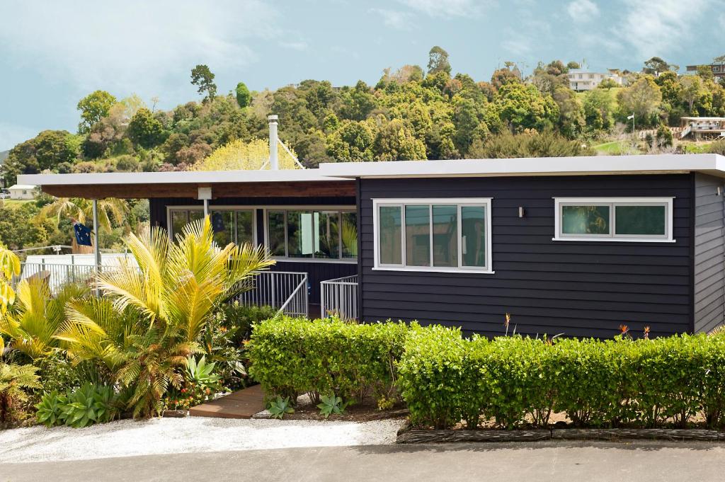 a black house with bushes and trees at The Black Bach in Russell