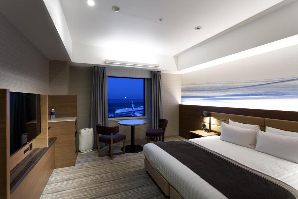 a hotel room with a bed and a table and a window at Haneda Excel Hotel Tokyu Haneda Airport Terminal 2 in Tokyo