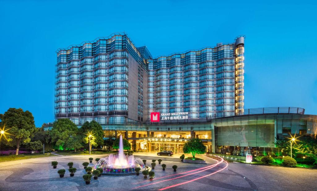a hotel with a fountain in front of a building at Grand Millennium Shanghai HongQiao in Shanghai