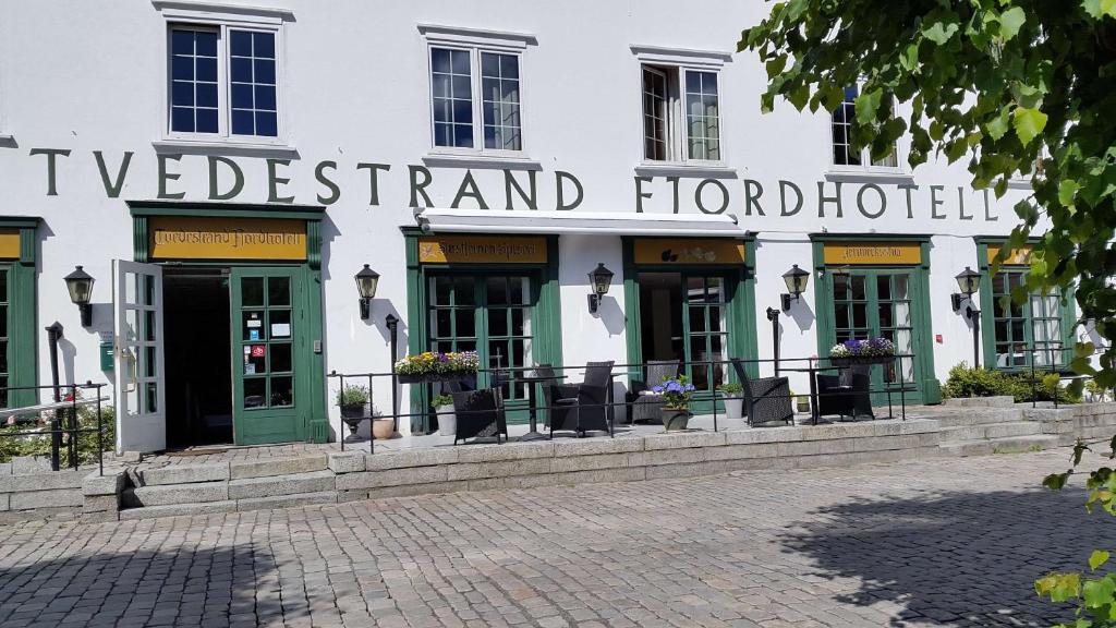 a white building with the wordsvelt island hotel at Tvedestrand Fjordhotell - Unike Hoteller in Tvedestrand