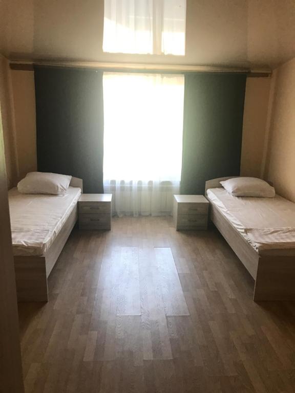 a large room with two beds and a window at Гостиница Альянс in Karagandy