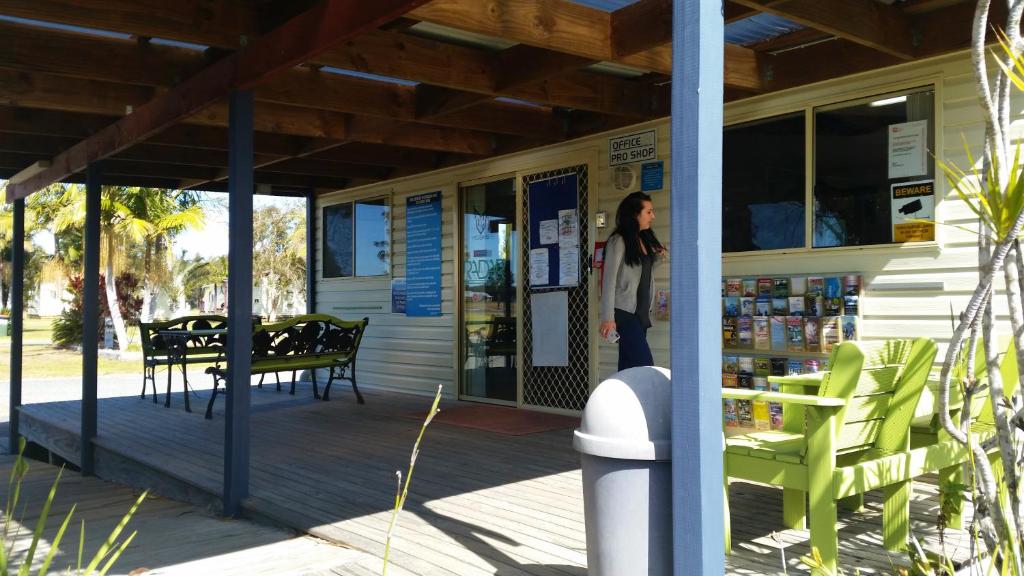 a woman is standing outside of a store at Stoney Park Holiday Park in Telegraph Point