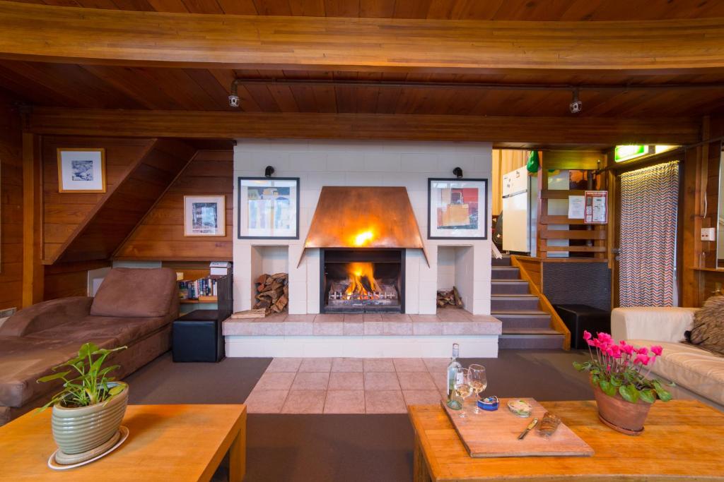 a living room with a fireplace in a house at Aneeki Ski Lodge in Thredbo