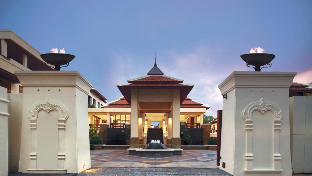 a large house with a gate and a building at Mövenpick Resort Bangtao Beach Phuket in Bang Tao Beach