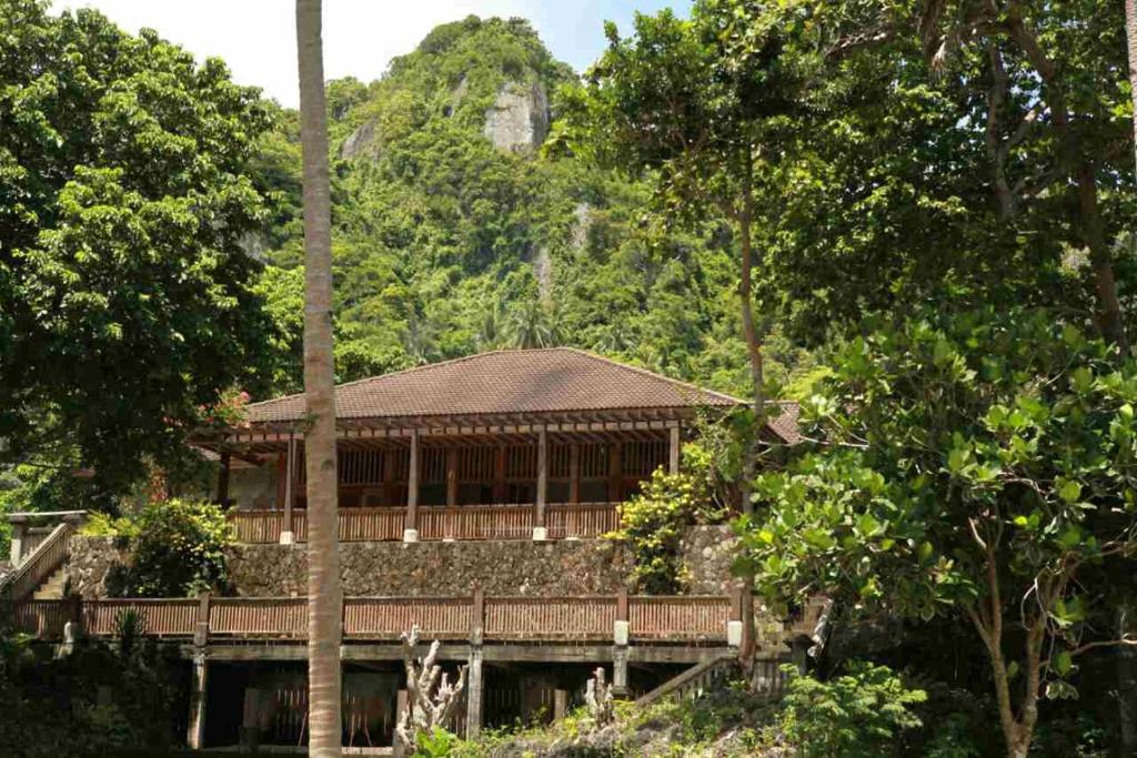 um edifício numa floresta com uma montanha ao fundo em Dapitan Beach Villa em Dapitan