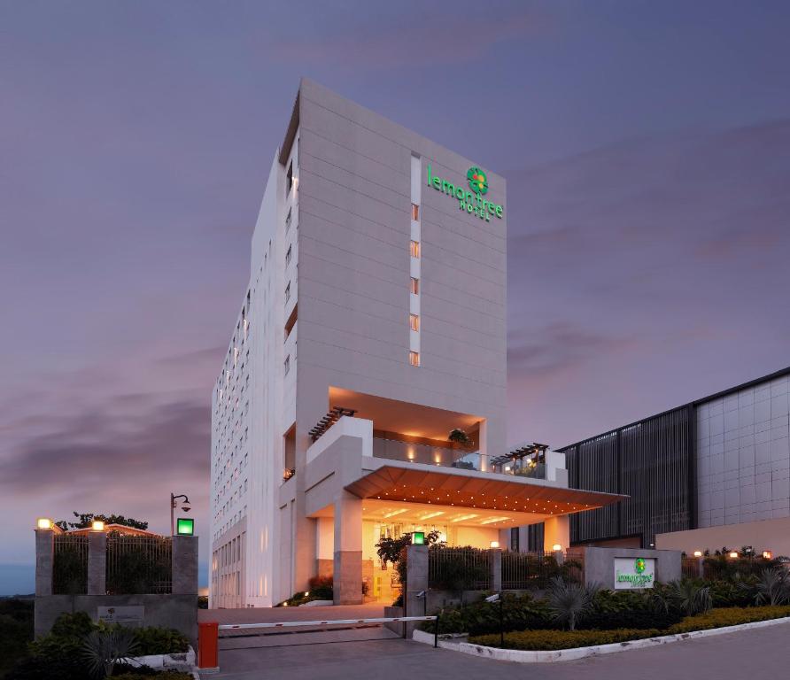 a large white building with a green sign on it at Lemon Tree Hotel, Gachibowli, Hyderabad in Hyderabad