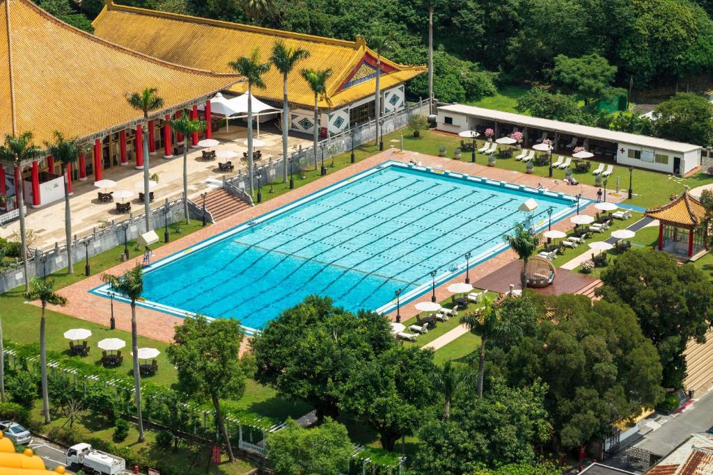 an overhead view of a large swimming pool with tables and chairs at The Grand Hotel in Taipei